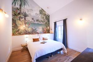 a bedroom with a bed with a painting on the wall at Le Clos des Merveilles in Rognes +18 photos
