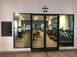 カジャンにあるMishal’s Homestay-Vista Bangi Studio Service Apartmentのガラスのスライド式ドア付きのジム、男性のエクササイズを提供しています。