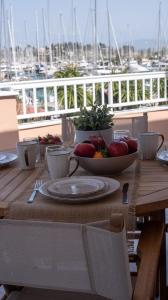 einen Holztisch mit einer Schale Obst auf dem Balkon in der Unterkunft Christina's apartment in Kontokali