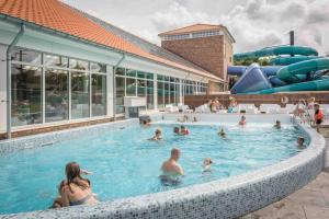 a group of people in a pool at a water park at Luxe 8 persoons ‘Golfvillatexel’ vlakbij zee in De Cocksdorp
