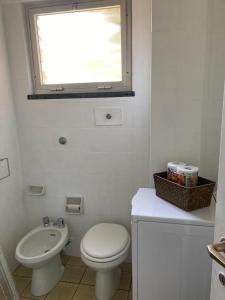 a bathroom with a toilet and a sink and a window at Aurea Bonassola in Bonassola