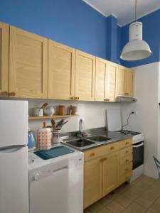 uma cozinha com armários de madeira e um frigorífico branco em Aurea Bonassola em Bonassola