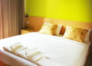 Bang Bo的住宿－BANGKOK.GRAND.RESORT，一间卧室配有一张白色的床和绿色的墙壁