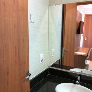 uma casa de banho com 2 lavatórios e um espelho em KK Palace Hotel em Eunápolis