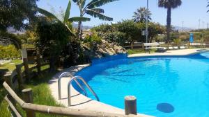 a large blue swimming pool with a wooden fence around it at Cabañas Villa Los Platanos in La Serena