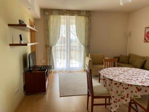 - un salon avec une table et un canapé dans l'établissement Bernadett Villa Apartman 2, à Bük