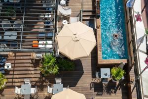 an overhead view of a pool with umbrellas and a swimming pool at Mercure Toulouse Centre Saint-Georges in Toulouse