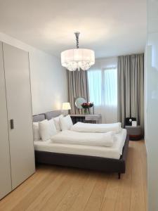 a bedroom with a large bed and a chandelier at SOLE DI DIANA LUXURY Apartments in Peschiera del Garda +31 photos