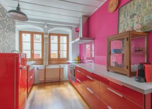 eine Küche mit rosa Wänden und einer Arbeitsplatte in der Unterkunft Appartement de vacances Un ange passe à Porrentruy in Pruntrut