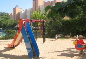 un parque infantil con tablas de surf en la arena en un parque en Islantilla a 50 metros de la playa, en Islantilla