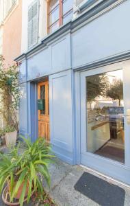 ein blaues Gebäude mit einer großen Glastür in der Unterkunft Appartement de vacances Un ange passe à Porrentruy in Pruntrut