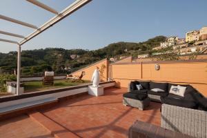 a patio with a couch and chairs on a roof at La Doppia Terrazza in Lerici