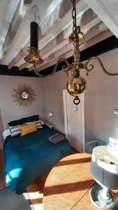 a bedroom with a bed and a table and a chandelier at Chambre d'hôtes Abbatiale in Bernay