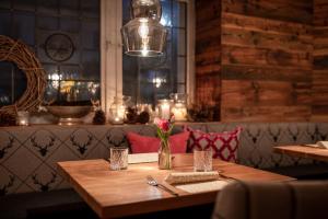 a wooden table in a restaurant with a light fixture at Romantik Landhotel 3Kronen in Adelsdorf