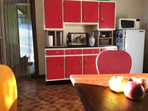 Piégut-PluviersにあるMaison Mercrediのキッチン(赤いキャビネット、テーブル、冷蔵庫付) +11枚の写真