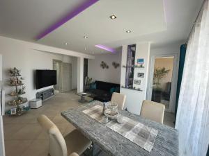 ein Wohnzimmer mit einem Tisch, Stühlen und einem TV in der Unterkunft Luxury Beachhouse Apartment Boa Vista in Sal Rei