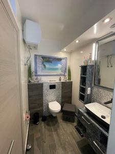 a bathroom with a toilet and a sink and a mirror at Luxury Beachhouse Apartment Boa Vista in Sal Rei