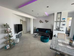 uma sala de estar com um sofá preto e uma árvore de Natal em Luxury Beachhouse Apartment Boa Vista em Sal Rei