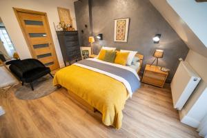1 dormitorio con 1 cama con manta amarilla en LA CORMELLERIE, en Saint-Ay