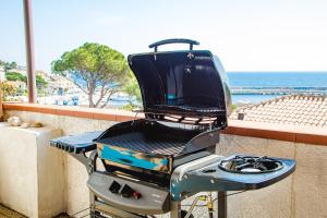 a grill sitting on a balcony with the ocean in the background at Ti porto al mare Apartment IUN P7641 in Cala Gonone