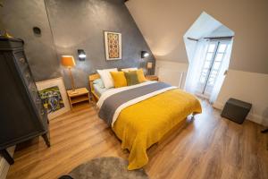a bedroom with a bed with a yellow blanket at LA CORMELLERIE in Saint-Ay