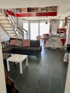 sala de estar con sofá y mesa en Port Brescou, T3 en duplex climatisé, superbe vue sur le port, en Cap d'Agde
