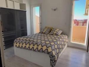 Un dormitorio con una cama con una manta. en Port Brescou, T3 en duplex climatisé, superbe vue sur le port, en Cap d'Agde