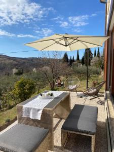 einen Tisch, Stühle und einen Regenschirm auf einer Terrasse in der Unterkunft Casa Monte Calvo in Izola