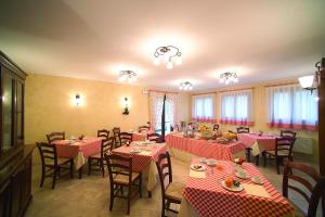 a restaurant with red and white tables and chairs at Alloggio Franciscus in Arquà Petrarca