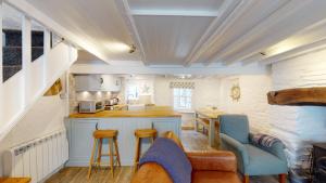 a kitchen with a couch and chairs in a room at Lobster Cove, 50 yards from the sea in Port Isaac