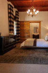 a bedroom with a large bed and a chandelier at Bloemendal Wine Estate Accommodation in Cape Town