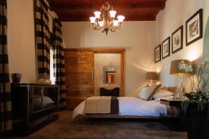 a bedroom with a bed and a chandelier at Bloemendal Wine Estate Accommodation in Cape Town
