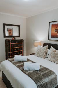 a bedroom with two twin beds and a dresser at Bloemendal Wine Estate Accommodation in Cape Town