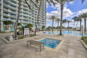 a bench next to a swimming pool with a building at Heated Pool Access! Waterfront Fort Myers Condo in Fort Myers