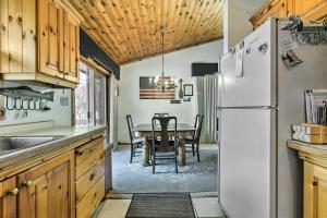 a kitchen with a table and a white refrigerator at Lakefront Phelps Cottage with Private Boat Dock in Phelps