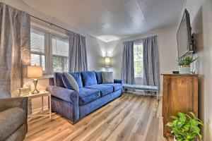 a living room with a blue couch and some windows at Family-Friendly Hideaway Near Presque Isle! in Erie