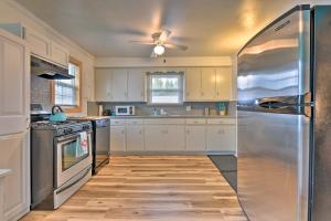 a kitchen with white cabinets and a stainless steel refrigerator at Family-Friendly Hideaway Near Presque Isle! in Erie