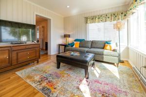 a living room with a couch and a tv at Waterfront Edenton Bay Cottage - Walk to Dtwn in Edenton