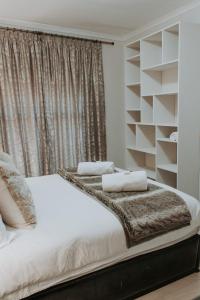 a bedroom with a white bed and a window at Bloemendal Wine Estate Accommodation in Cape Town