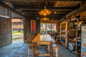 uma sala de jantar com uma mesa de madeira e cadeiras em Indi house em Sapa