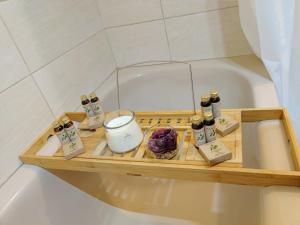 a wooden tray sitting in a bath tub with cosmetics at LE ROI SOLEIL • 4min Château Versailles • 1min Gare Versailles Rive Gauche in Versailles