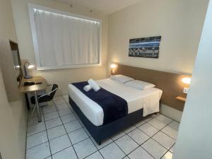 Habitación de hotel con cama y mesa pequeña en Hotel de Carvalho, en Florianópolis