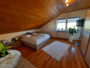 a attic room with a bed and a window at Pflaumers Ferienwohnung in Eppingen +48 photos