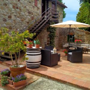 a patio with a bunch of potted plants and an umbrella at B&B la luna nel Pozzo in Todi