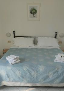 a bed with a white comforter and pillows at Hotel Villino Gallodoro in Taormina