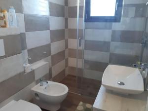 W łazience znajduje się toaleta i przeszklony prysznic. w obiekcie VILLA INDIPENDENTE AL MARE BUDONI w mieście Tanaunella