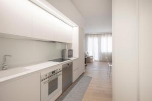 a white kitchen with a sink and a microwave at Attico incantevole con Jacuzzi idromassaggio e sauna in Treviso