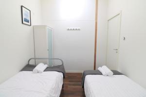 two beds in a room with white walls at Bright & Spacious Apartment in Kinna Center in Kinna