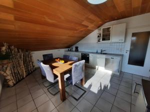 cocina con techo de madera, mesa y sillas en Pflaumers Ferienwohnung, en Eppingen