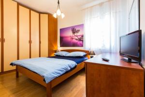 a bedroom with a bed and a flat screen tv at Apartment Anna in Zadar